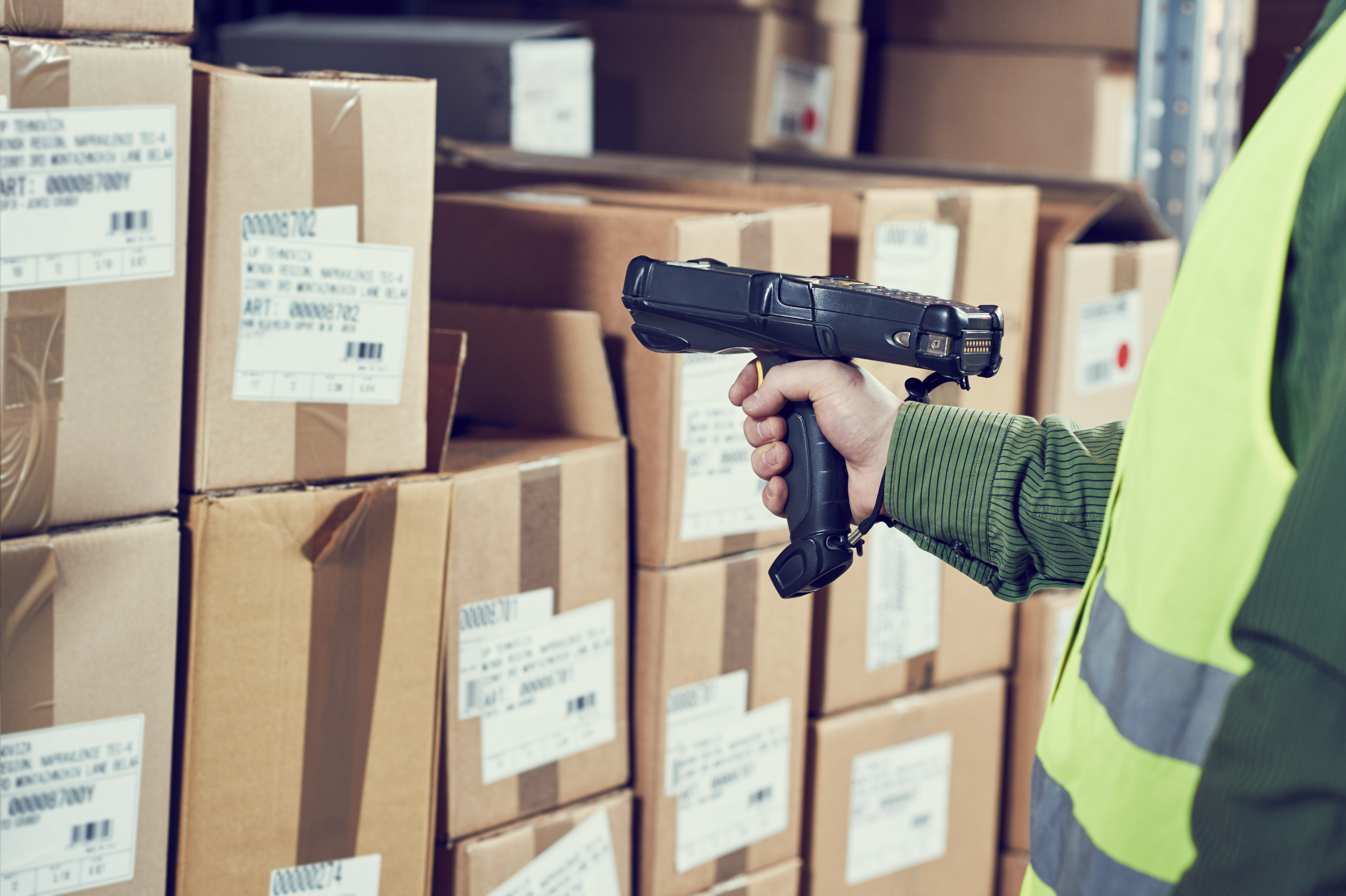 man holding an rf gun or handheld device while scanning a label